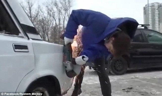 俄罗斯一名男子在停车场要停车，因有车辆停斜的，挡住他的车格，他便拿出电锯，锯下邻车一角。(取材自脸书)